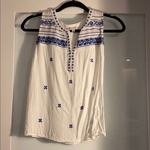 Sleeveless white top with blue embroidery